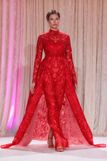 Nardos designed gown with a vision of allure draped in intricate red lace with a majestic overskirt, exuding regal romance.