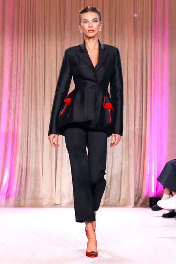 Nardos designed classic black suit featuring sleek tailoring and bold red embroidery, for an ensemble that dances between elegance and statement.