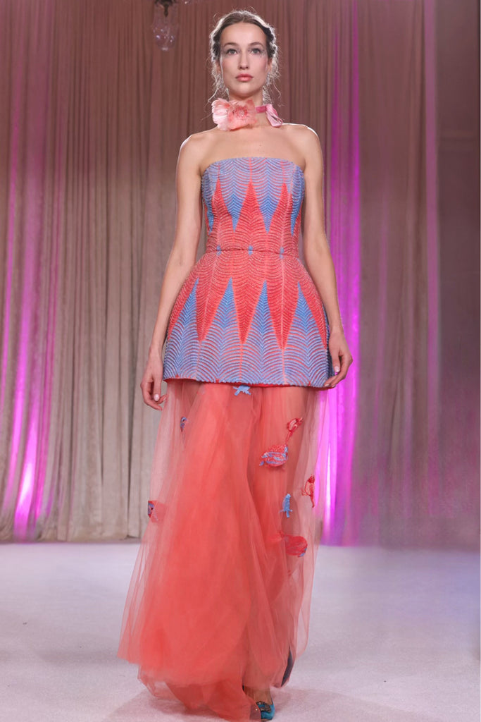 Nardos designed An ethereal strapless gown featuring a geometric patterned bodice with a peplum waist, flowing into a sheer coral tulle skirt.