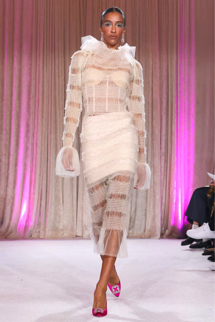 Nardos designed sheer dress covering a white bustier and mini skirt, with a flared collar and long sheer cuffs