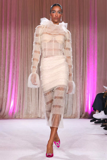 Nardos designed sheer dress covering a white bustier and mini skirt, with a flared collar and long sheer cuffs